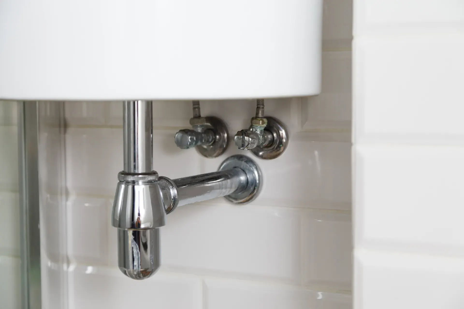 Professionel VVS-installation med rør og fittings i moderne badeværelse.