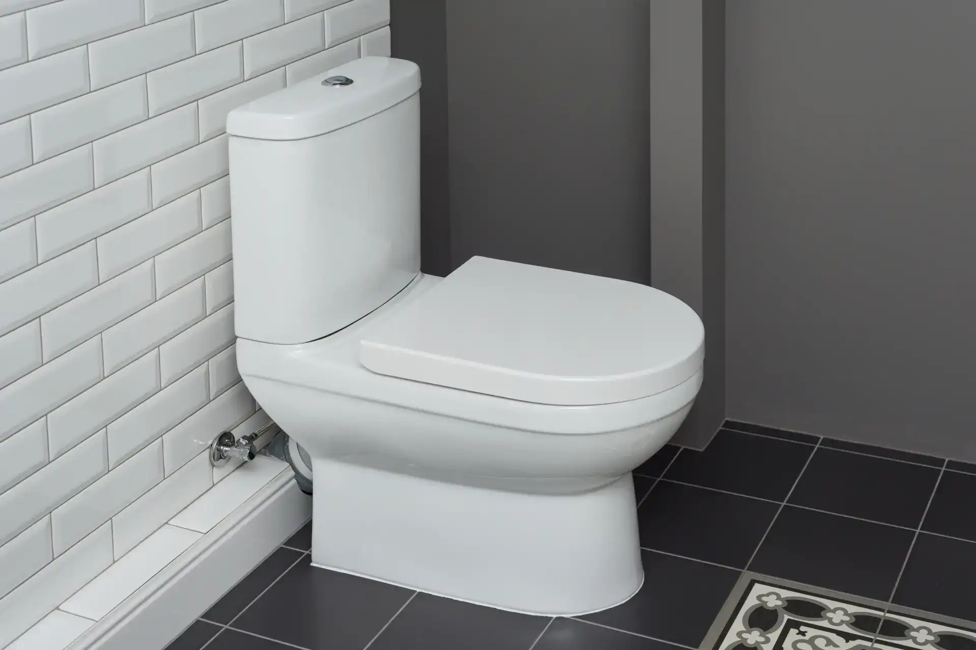 Højtaler til toilet i moderne badeværelse med hvidt toilet og sort flisegulv.